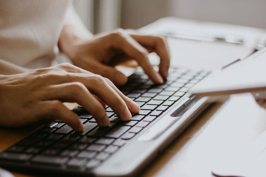 a woman typing an seo blogpost on her keyboard